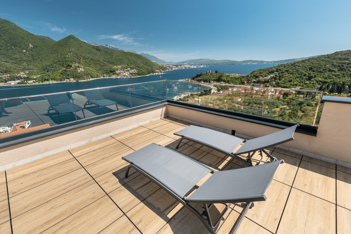 The pool terrace, loungers and the bay beyond