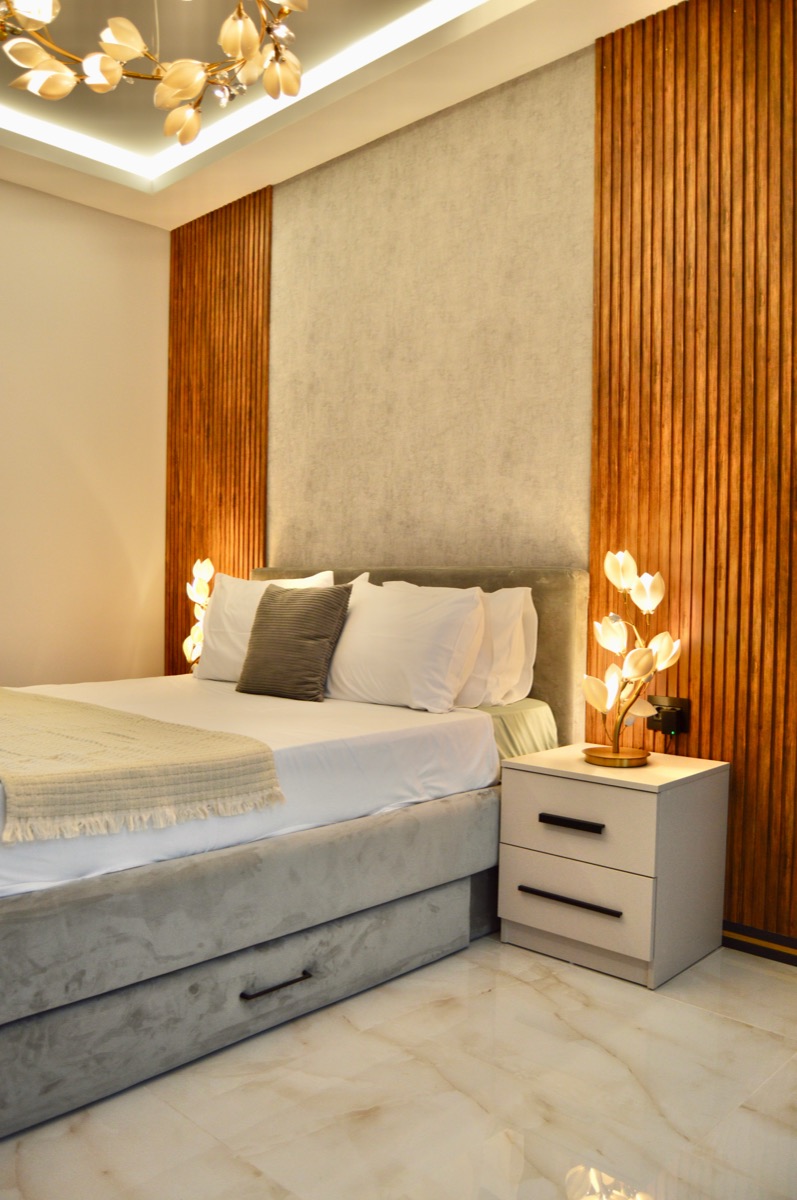 A bedroom with warm timber panelling