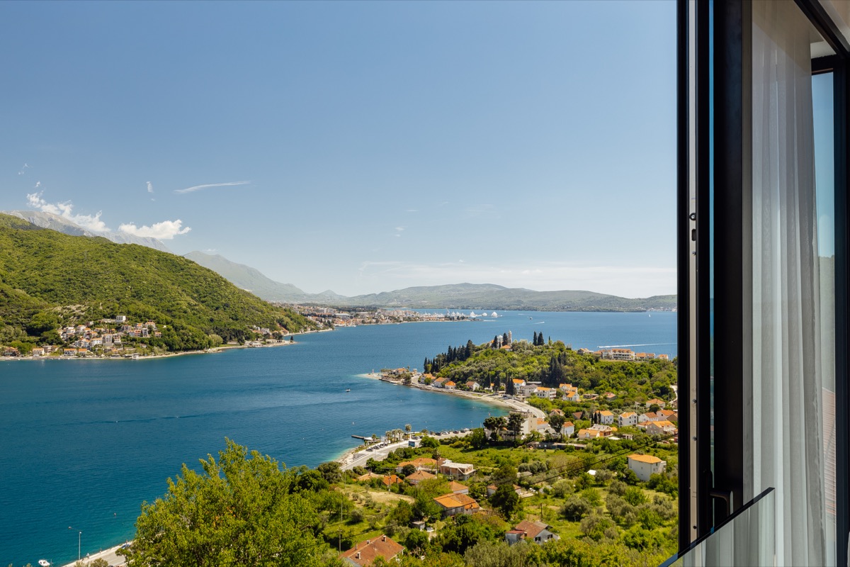 The bay framed by the villa's glass doors