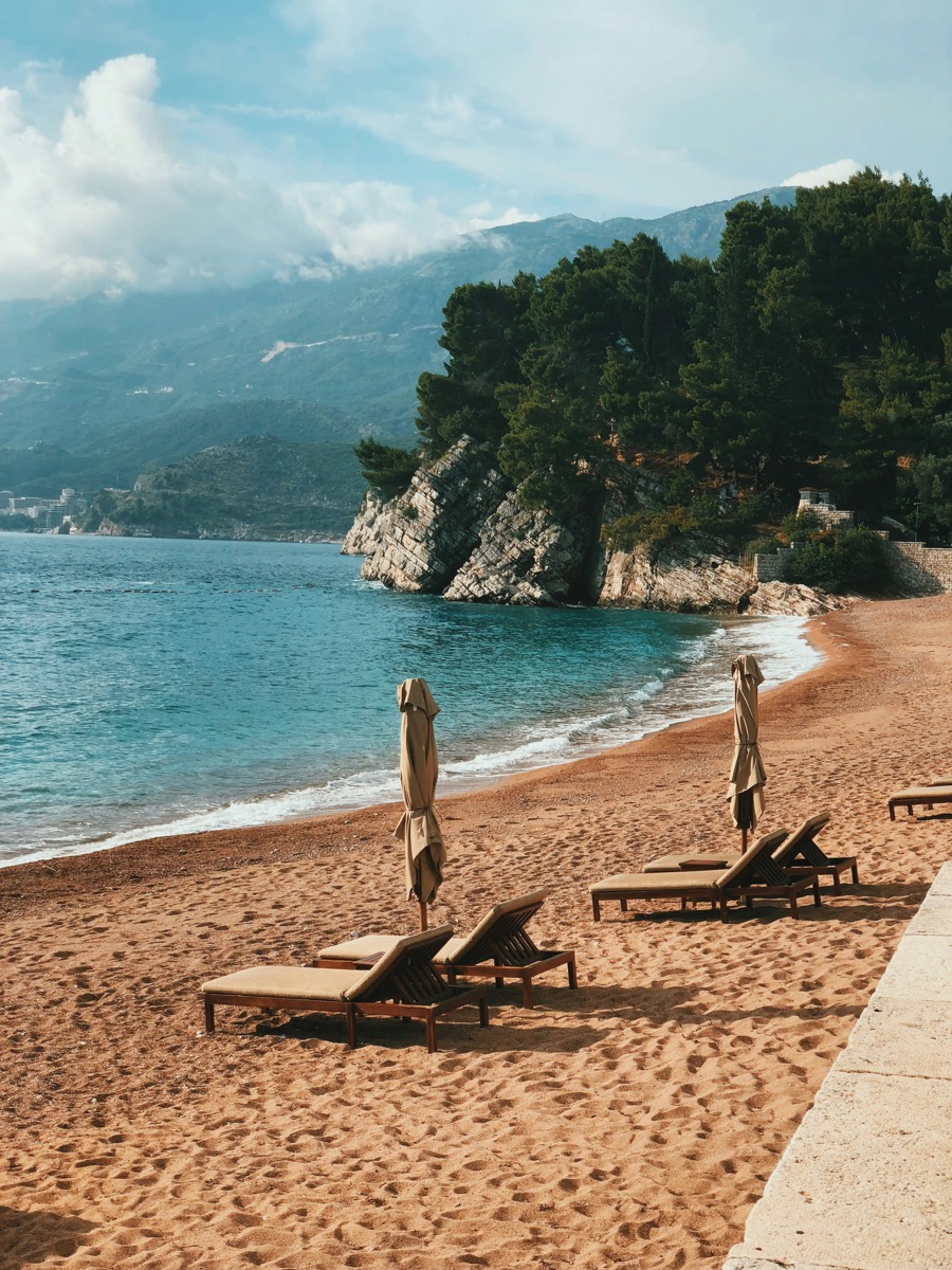 Loungers on an empty beach below the headland in autumn