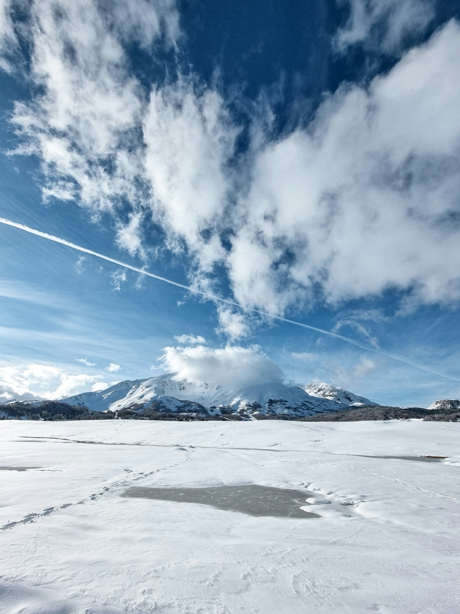 Snow-covered mountains under a bright winter sky