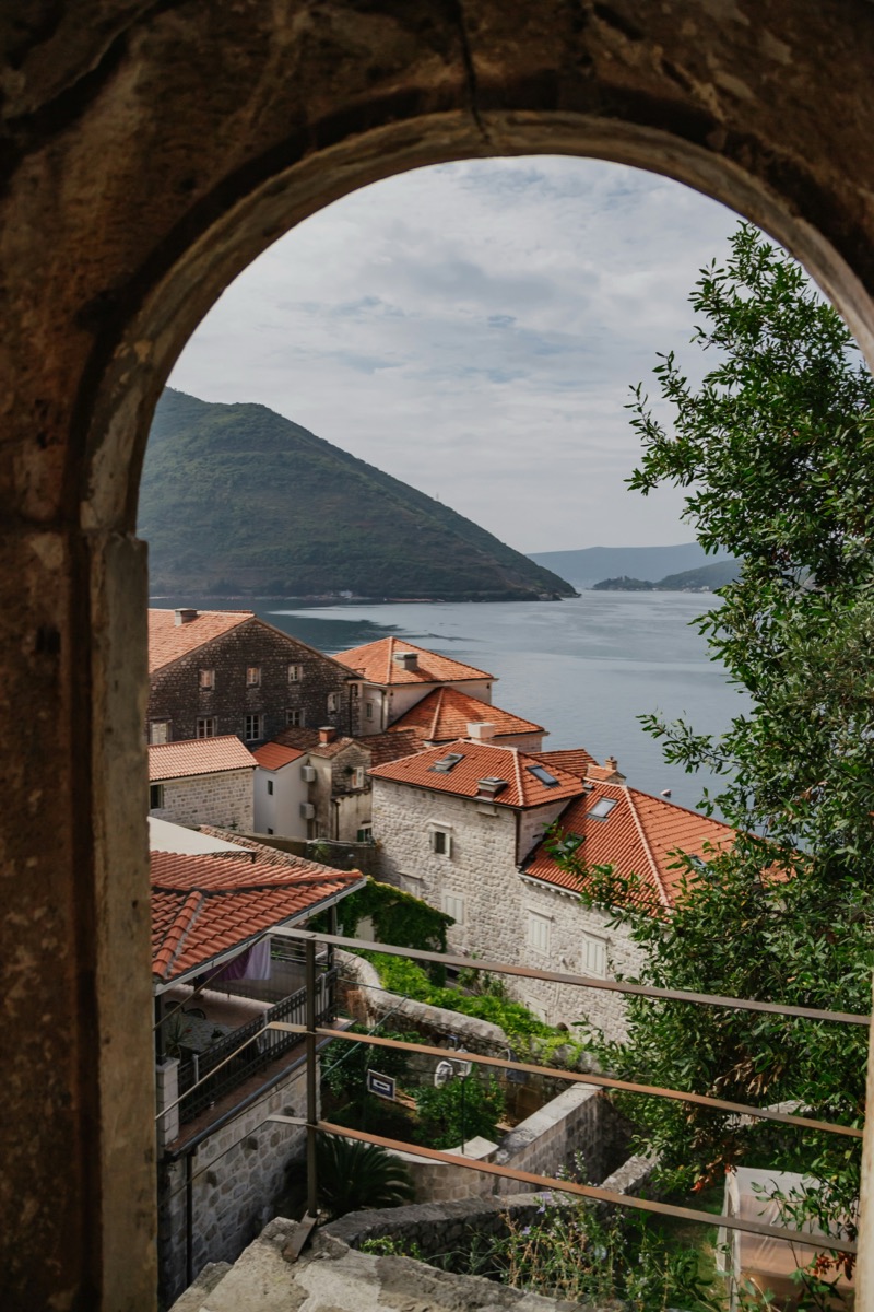 A stone archway framing the rooftops and the bay beyond