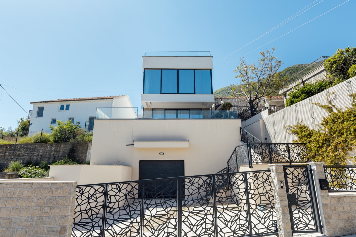 The villa seen from the approach, glass and white render